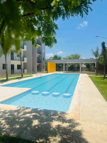 a swimming pool in front of a building at Departamento Orion 3 rooms planta baja en Cancun by EITA in Cancún