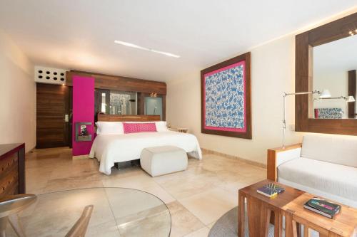 a large bedroom with a bed and a couch at Hotel Xcaret Mexico All Parks All Fun Inclusive in Playa del Carmen
