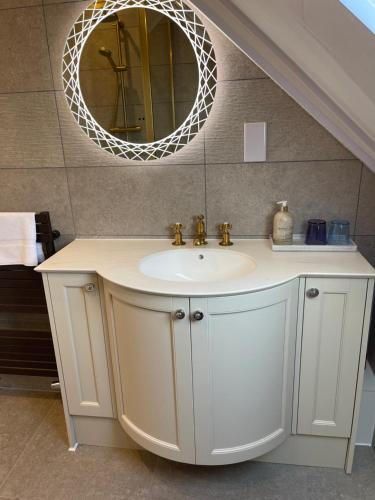 a bathroom with a sink and a mirror at Kingston Guesthouse in Edinburgh