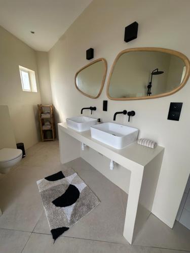 Un baño con dos lavabos y un espejo grande. en Palm View, en Willemstad