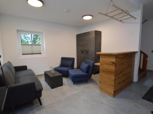 a waiting room with two blue chairs and a table at Leni Top 1 in Dienten am Hochkönig