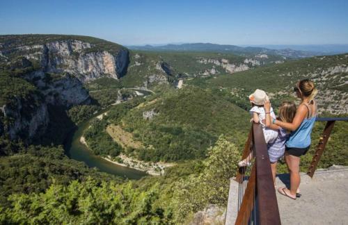 a woman and two children standing on the edge of a viewing tower at Villa de Charme avec Piscine Calme & Élégance in Aubenas