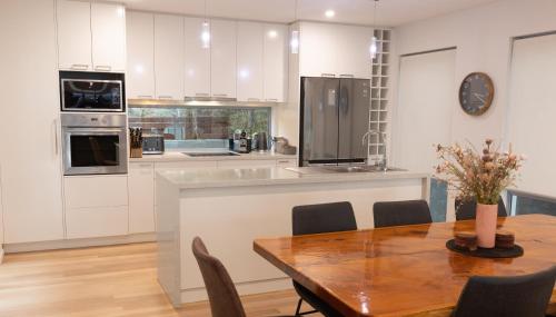 a kitchen with a wooden table and a dining room at The MBM - Modern 4BR Home, Spacious, Views, Ideal for Groups in Montagu Bay