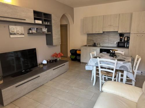 una cucina e un soggiorno con tavolo e sedie di Domu Grìsia Apartment Arzachena a Arzachena