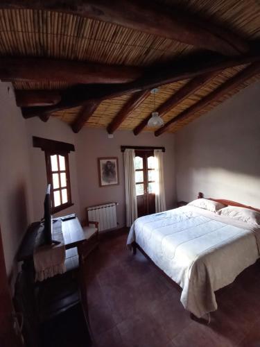 a bedroom with a large white bed and windows at Departamentos Complejo Turístico Cruz Mendoza in Tilcara
