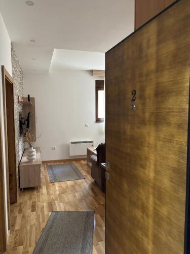 a room with a door and a living room at Alexandro Apartmani Zlatibor in Zlatibor