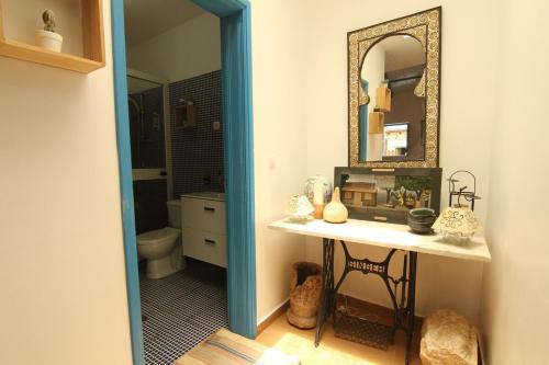 a bathroom with a vanity and a mirror and a sink at Casinha Azul Cidade Velha - Blue House Old Town in Cidade Velha