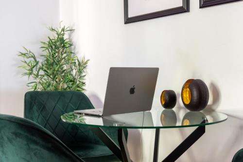 Una mesa de cristal con una computadora portátil encima. en Sleep better here! central oasis of well-being, en Graz