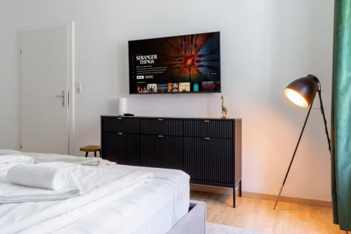 Un dormitorio con una cama y un televisor en la pared. en Sleep better here! central oasis of well-being, en Graz