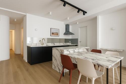 - une cuisine avec une table et des chaises en marbre dans l'établissement Paris Grenelle Suite Champs de Mars, à Paris