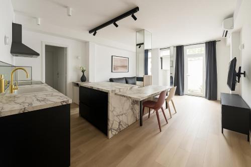 - une cuisine avec un comptoir et une table avec un évier dans l'établissement Paris Grenelle Suite Champs de Mars, à Paris