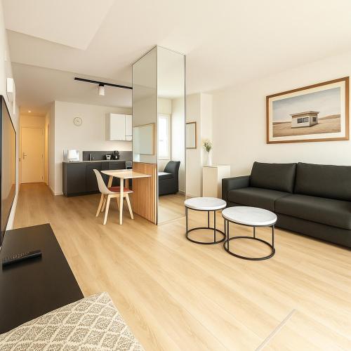 un salon avec un canapé et une table dans l'établissement Paris Grenelle Suite Champs de Mars, à Paris