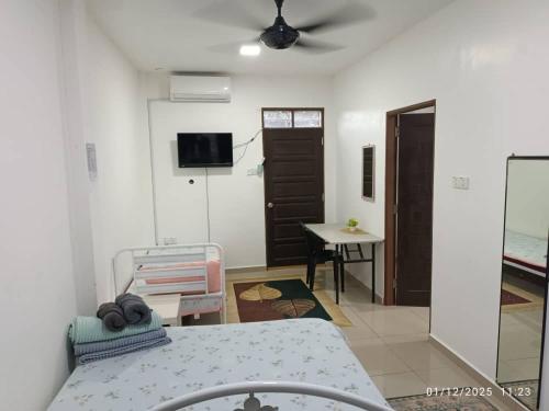 a room with a bed and a table and a tv at VILLA ANJUNG TAMU in Kampong Pak Sabah