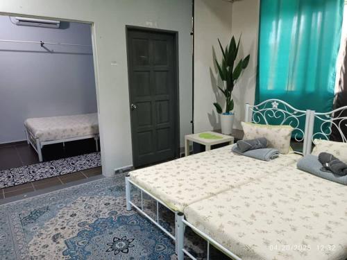 a bedroom with a large bed and a door at VILLA ANJUNG TAMU in Kampong Pak Sabah