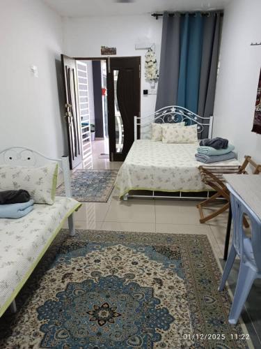 a living room with two beds and a rug at VILLA ANJUNG TAMU in Kampong Pak Sabah