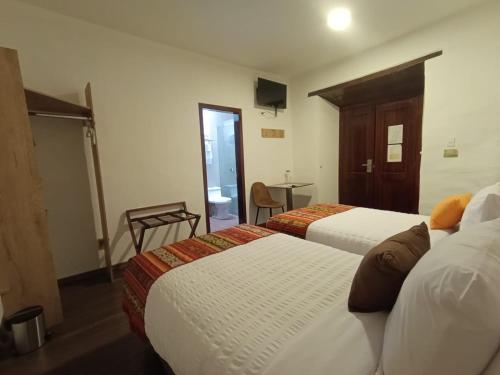 a hotel room with two beds and a table at Casona Tobar Hotel in Quito
