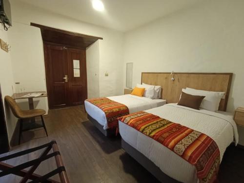 a hotel room with two beds and a desk at Casona Tobar Hotel in Quito