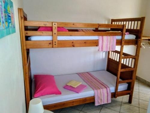 a wooden bunk bed with pink pillows on it at Apartments by the sea Cove Bristva, Korcula - 15205 in Blato