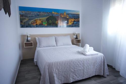 a bedroom with a white bed and a painting on the wall at Villas Privadas EL DESCANSO in La Rinconada