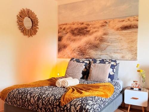 une chambre avec un lit et un tableau au mur dans l'établissement LES DUNES Studio Ideal couple,solo,famille&pro, à Vitry-sur-Seine