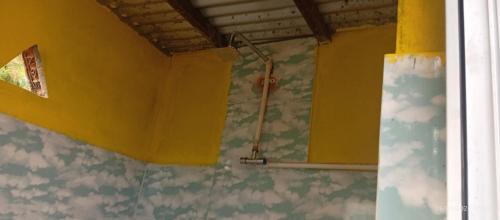 a bathroom with a shower in a yellow wall at Everest Home Stay Temal Kalimati Tower in Thapathali
