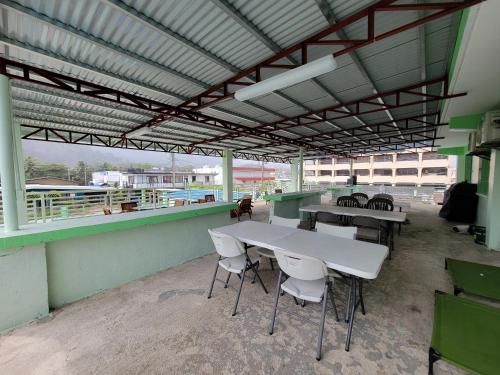 a patio with tables and chairs in a building at Green Flash Dive Inn in Garapan