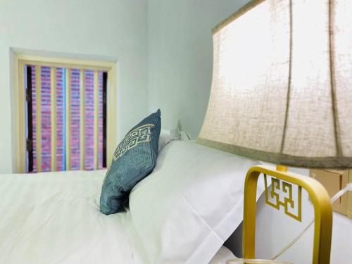 a bedroom with a bed with a blue pillow and a window at 鼓浪屿书香庄园民宿 in Xiamen