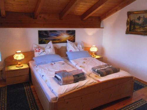 a bedroom with a wooden bed with two lamps at Ferienwohnung Buchner | Chiemgau Karte in Grassau