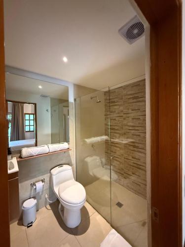 um banheiro com vaso sanitário e box de vidro em Hotel Jardin Boutique rodadero em Santa Marta