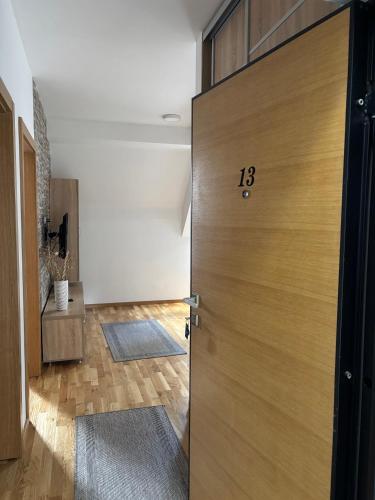 a wooden door with the number on it in a room at Alexandro Apartmani Zlatibor in Zlatibor