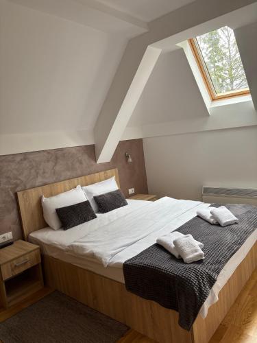 a bedroom with a large bed with white sheets and pillows at Alexandro Apartmani Zlatibor in Zlatibor