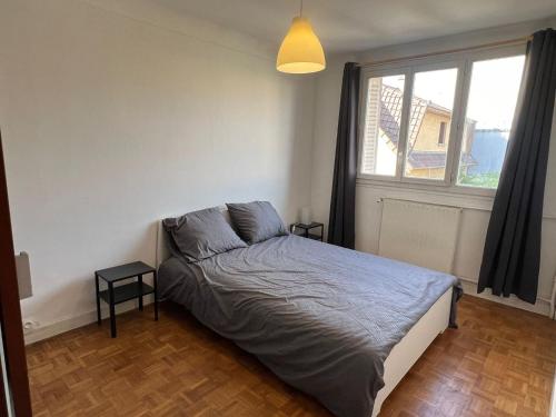 une chambre avec un lit et une grande fenêtre dans l'établissement Joli appartement à Montreuil, proche des nouvelles stations de métro, à Montreuil