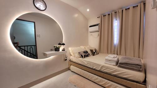 a bedroom with a bed with a round mirror at Vacation Home in Naga City -Jacobes Place in San Felipe