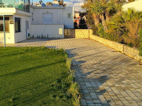 a brick walkway in front of a house at BlueTel Lixouri in Lixouri