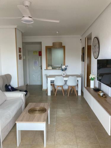 a living room with a couch and a table at Edificio TORREMAR vistas al mar, orientación norte, Wifi y Smart-TV in Oropesa del Mar