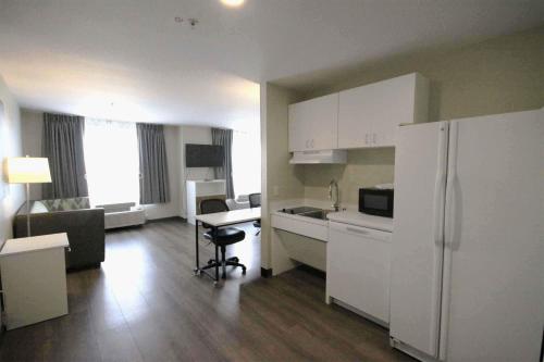 a kitchen with a white refrigerator and a table at Extended Stay America Suites - Albuquerque - Rio Rancho Blvd in Rio Rancho