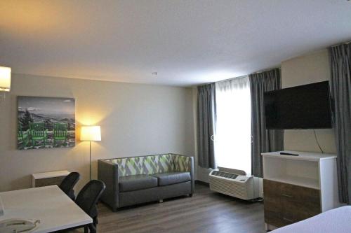 a living room with a couch and a tv in a hotel room at Extended Stay America Suites - Albuquerque - Rio Rancho Blvd in Rio Rancho