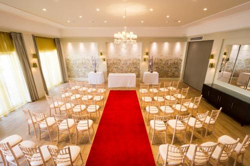 a banquet hall with a red carpet and chairs at The Orchid Hotel in Bournemouth
