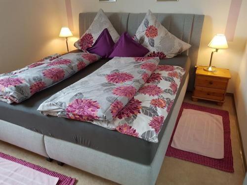 a bed with purple and pink pillows on it at 1-bedroom holiday apartment in Dittishausen