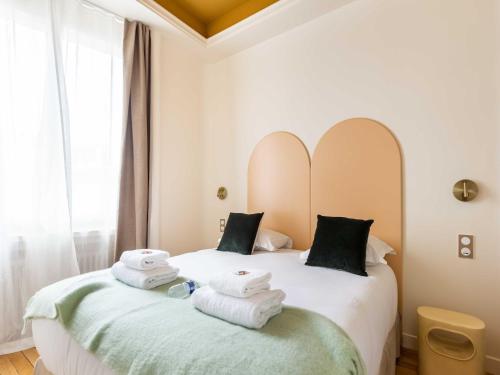 une chambre avec deux lits avec des serviettes dessus dans l'établissement Port-Royal Residence - Cosy apartment - 1BR- 4P, à Paris
