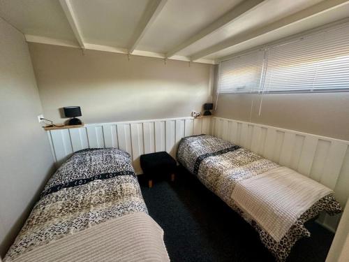 two beds in a small room with a window at Holiday Home in Elim near Slagharen Park in Elim