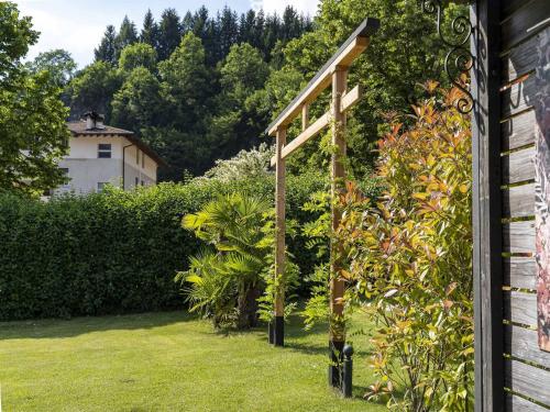 a garden with a wooden archway in a yard at Apartment in Mezzolago with Lake Ledro Views in Mezzolago