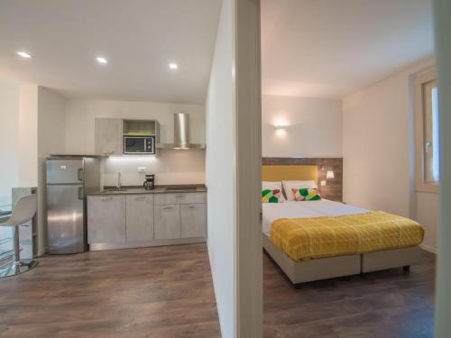 a bedroom with a bed and a kitchen at Apartment in Mezzolago with Lake Ledro Views in Mezzolago