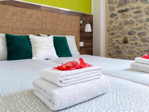 a bed with white towels and a red rose on it at Apartment in Mezzolago with Lake Ledro Views in Mezzolago