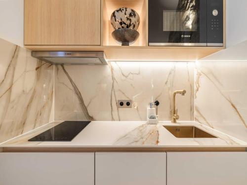 une cuisine avec un évier et un micro-ondes dans l'établissement Central historic loft by architect, near Louvre, à Paris