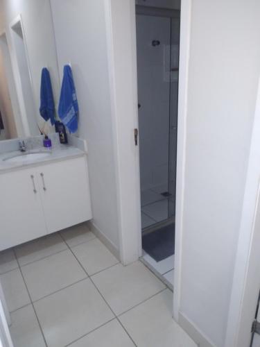 Un baño blanco con lavabo y ducha. en Condomínio Gran Felicita Castelo, en Belo Horizonte