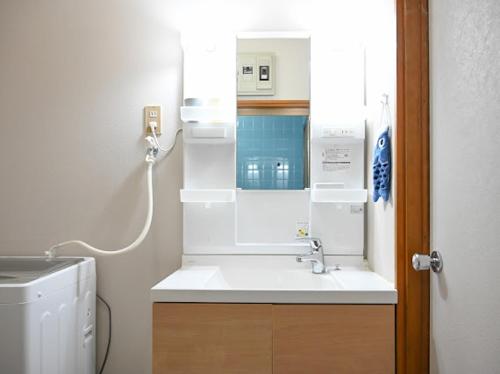 a bathroom with a sink and a washing machine at Two bathrooms, two toilets 6 mins walking distance from Keisei Takasago Station in Tokyo