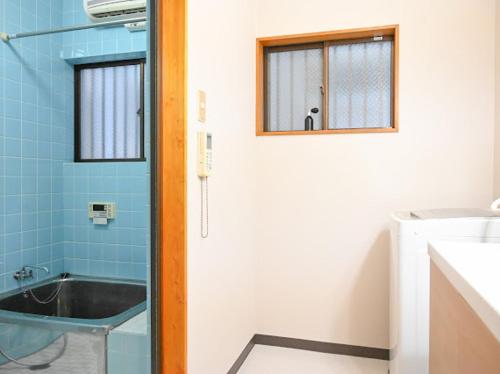 a bathroom with a tub and a sink and a window at Two bathrooms, two toilets 6 mins walking distance from Keisei Takasago Station in Tokyo