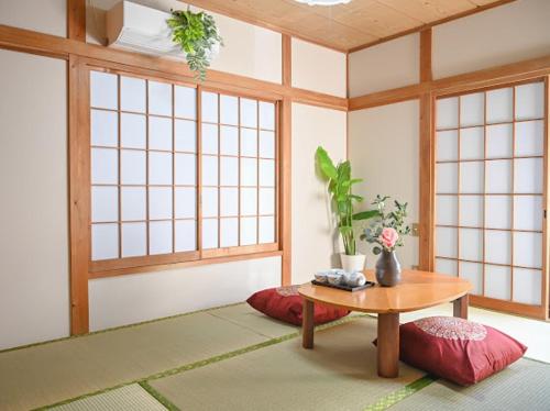 a room with a table and a room with windows at Two bathrooms, two toilets 6 mins walking distance from Keisei Takasago Station in Tokyo