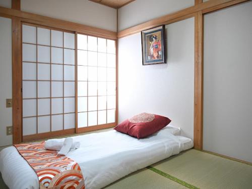 a room with a bed in a room with windows at Two bathrooms, two toilets 6 mins walking distance from Keisei Takasago Station in Tokyo